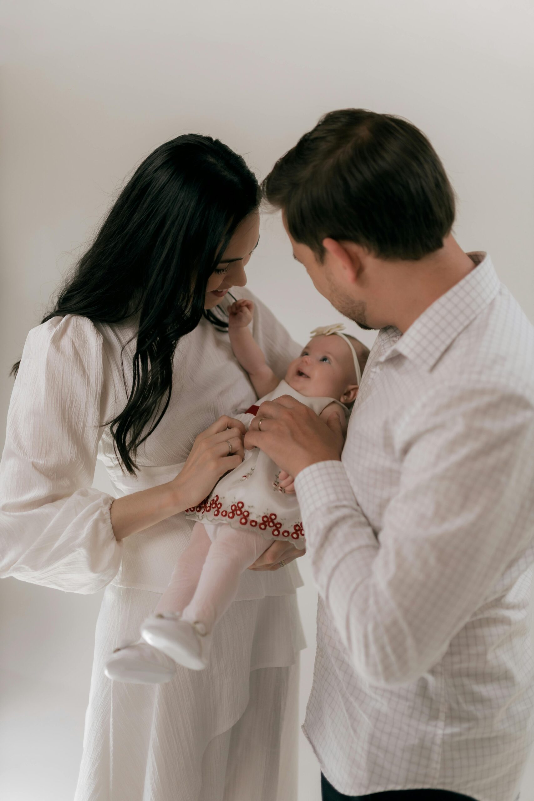 Loving parents hold their infant, capturing a tender family moment.